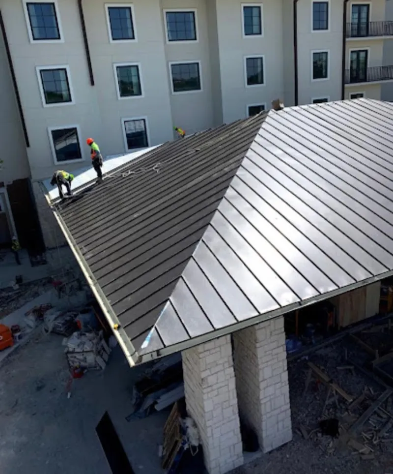 Crew installing standing seam metal roof panels on a commercial project in Sammamish